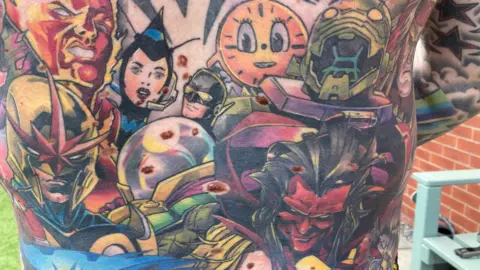 Simon Spark/BBC Close up shot of Radford's tattoos of Marvel characters. 