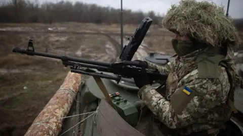 Roman Chop/Global Images Ukraine A Ukrainian crew with a machine gun looks out of a Marder 1A3 infantry fighting vehicle on December 7, 2023