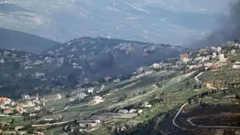 EPA Smoke rises from the southern Lebanese border town of Khiam following an Israeli strike, as seen from northern Israel (16 March 2026)