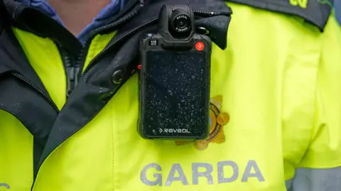 A close-up of garda officer's high-vis uniform and body-worn camera