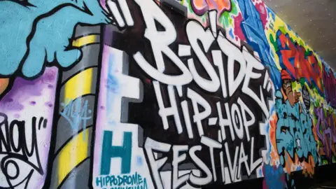 Fivesix Photography Graffiti is sprayed or painted on a wall at the festival