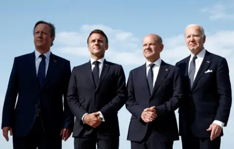 Reuters Britain's Foreign Secretary David Cameron, French President Emmanuel Macron, German Chancellor Olaf Scholz and U.S. President Joe Biden attend the international ceremony marking the 80th anniversary of the 1944 D-Day landings and the liberation of western Europe from Nazi Germany occupation