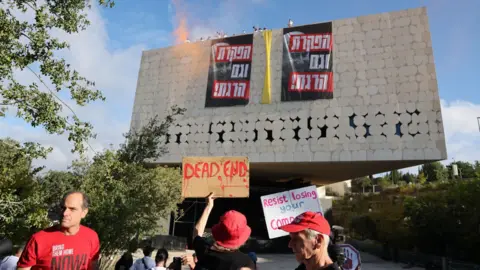 EPA Israeli protesters hang banners from the roof of the National Library in Jerusalem, saying: "You have abandoned and also killed." (3 September 2025)
