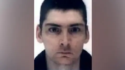 A man with cropped, dark hair looking directly into the camera.