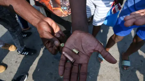 EPA Protesters show empty shell cases used by police to disperse a march in Maputo, Mozambique, 05 March 2025.