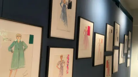 Sketches for Princess Diana by David Sassoon. They are in a mixture of colours, mainly green, blue and pink. Notes with little ticks and "please" and other notes can be seen written on the sketches.