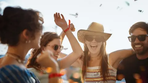 A group of people partying at a festival in the sunshine