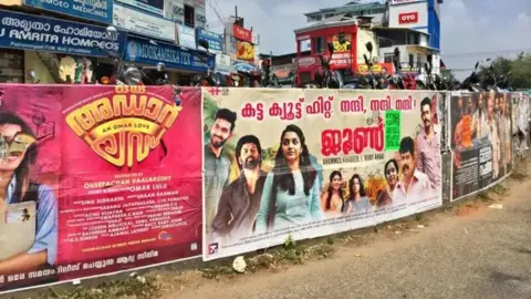 Getty Images Una pared cubierta de carteles de películas malayalam como Oru Adaar Love Story y June