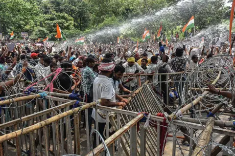 Police personnel use water cannon to disperse demonstrators during an ongoing protest against alleged irregularities in the Jharkhand Public Service Commission (JPSC) and Jharkhand Staff Selection Commission (JSSC) recruitment exams in Ranchi on August 10, 2026. 