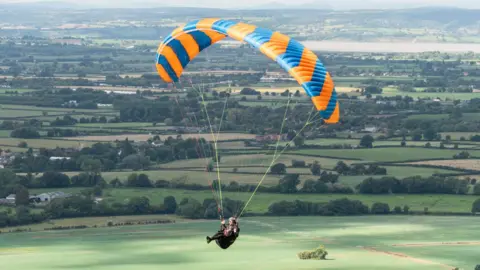 Getty Images A paraglider flies over English countryside.