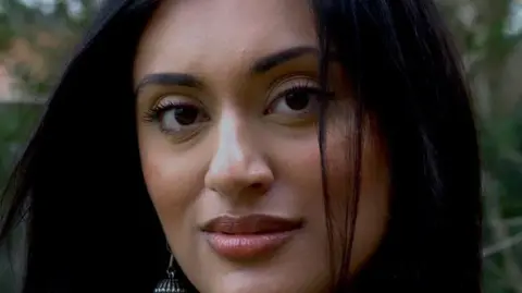 Wolverhampton Literature Festival A woman stood outside, with greenery behind her. She has long black hair and is looking directly at the camera