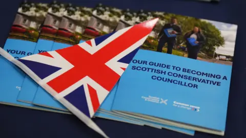 PA Media A union flag next to a leaflet detailing information on becoming a Scottish Conservative councillor.