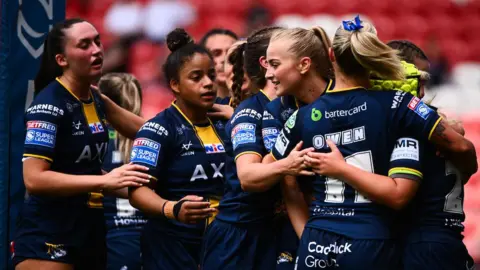 Leeds Rhinos celebrating after scoring a try against St Helens.