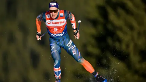 Gian Ehrenzeller/EPA/Shutterstock Andrew Musgrave in full ski attire, skiing towards the camera.