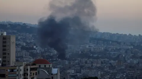 Reuters Smoke bellows from a Beirut into the sky. It's a busy city with a lot of buildings.