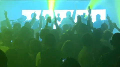 Silhouettes of people dancing in a nightclub