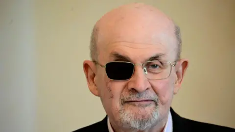 Getty pictures Sir Salman Rushdie in the picture. He wears glasses, with one dark side because it is blind.