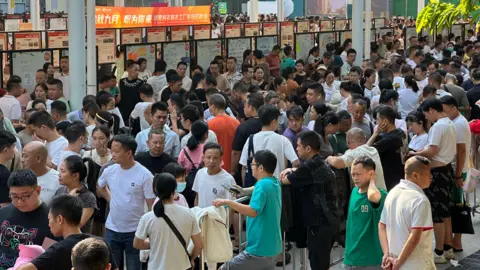 Penduduk setempat BBC/XIQING Wang berbondong -bondong ke pameran kerja di desa Lujiang, Distrik Haizhu