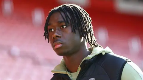 Moses Sesay in a black and green training jacket before a Southampton match.