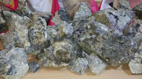 A photograph of Blue John. It loos like a pile of small rocks with blue and purple colours running through them.