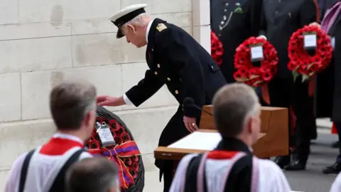 Reuters King Charles leans down to place a wreath at the base of the Cenotaph