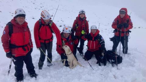 Rescuers with one of the dogs
