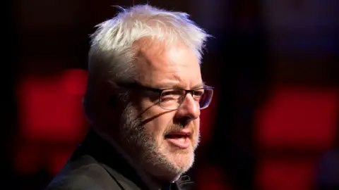 Carwyn Jones, who wears glasses and has a grey beard and short grey hair