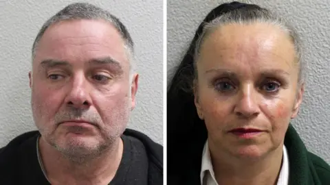 Metropolitan Police Police mugshots of McKenna on the left and his partner Smith on the right. McKenna is wearing black and has shor grey hair and stubble. Smith appears to have long hair tied back. She is wearing white and green.