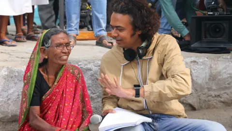 Courtesy: the writer and director of Sthal, Jayant Digambar Somalkar, explains a scene to an old female actor in the sets of the movie Marathi Sthal: A Match 