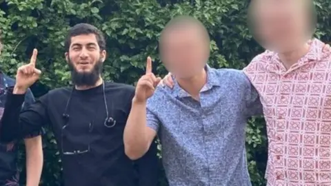 Contributed Mohammed Farraj pictured with two other men, whose faces are blurred.