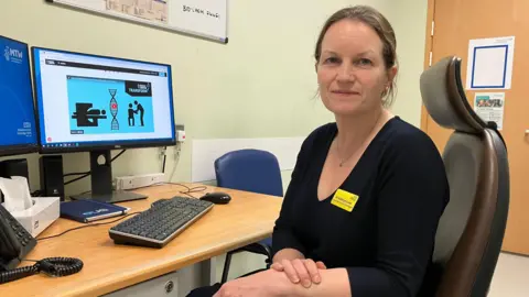 Leanne Rinne/BBC Dr Kathryn Lees. Consultant Clinical Oncologist, sitting at her desk in Maidstone Hospital .