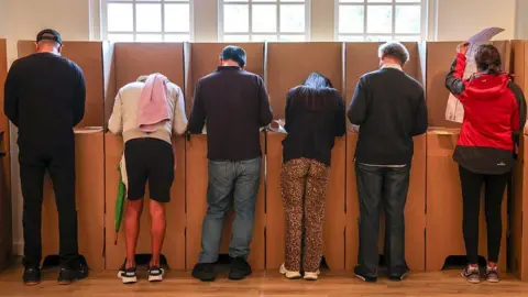 Getty Images Voters mark their ballot papers at a pre-polling centre in Sydney on May 2, 2025