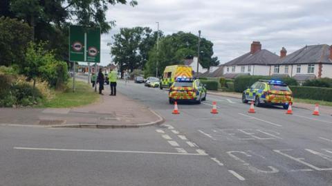 Police cars and an ambulance inside a cordon in Loughborough Road, Birstall, after a collision