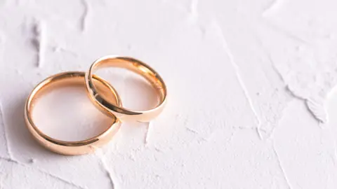 Two gold wedding rings on a white background