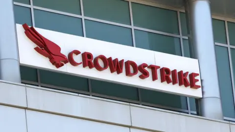 آرم EPA CrowdStrike در کنار ساختمان.  لوگو یک پرنده شکاری قرمز رنگ است که به نظر می رسد روی زمین پرواز می کند.