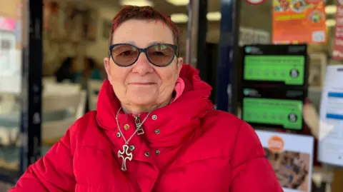 George Carden / BBC Jacqueline Wiltshire pictured outside a cafe. She says the town centre has declined