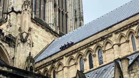 BBC/Oliver Day The firefighters pictured on the roof of the Minster