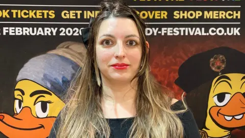 A woman stood in front of a display on the festival with ducks representing famous artworks