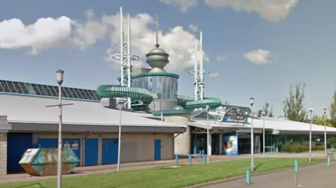 A large leisure centre building, with beige brickwork.