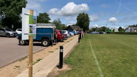 Matt Knight/BBC A general view of the edge of the cricket field's boundary at Dawson Fields and the adjacent public car park