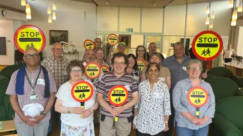 A group of people holding stop signs 