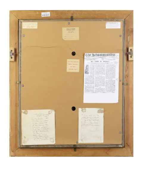Bonhams The back of a an old picture frame which is tan in colour and has news clippings pasted on it.