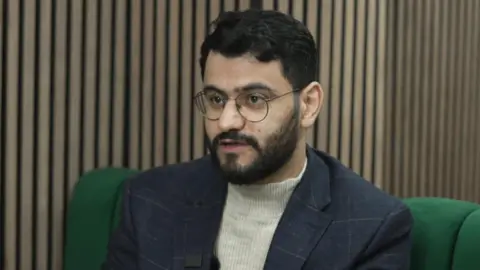 Motasem Zaid in a knitted top and blazer.