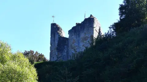 Michael Garlick/Geograph Ruined castle walls nestling among trees.