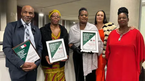 Jon Wright/BBC Five people in a line, holding framed certificates.