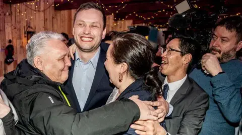 Getty Images Chairman of Demokraatit, Jens-Frederik Nielsen (C), celebrates during the election party at Demokraatit by cafe Killut in Nuuk, March 11, 2025