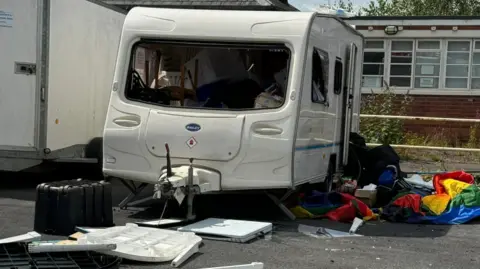 Carl Gratty Pride caravan with windows smashed and contents strewn around the floor
