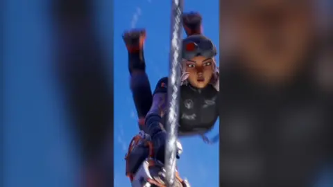 Female game character in a racing suit swings from a metal wire.