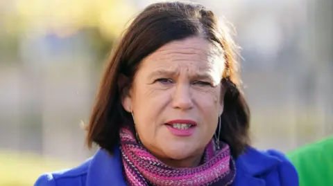 PA Media Mary Lou McDonald wearing blue jacket and pink scarf