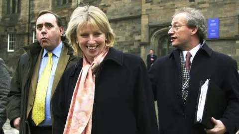 A ministra escocesa das Pescas da PA Media, Rhona Brankin, chega para conversar com os pescadores que protestam no parlamento escocês em Edimburgo com o primeiro-ministro Henry McLeish (à direita) e Alex Salmond. * Centenas de pescadores marcharam até ao Parlamento Escocês numa tentativa de persuadir o Executivo a compensá-los por amarrarem os seus barcos para conservar os stocks de peixe. Uma delegação reuniu-se esta manhã com a Sra. Brankin para a avisar que a indústria pesqueira corre o risco de entrar em colapso total, a menos que seja apresentado um pacote financeiro.